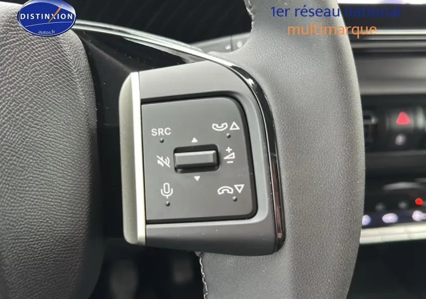 Gros plan sur les commandes vocales et audio au volant du Citroën C3 Aircross gris, intérieur moderne et épuré.