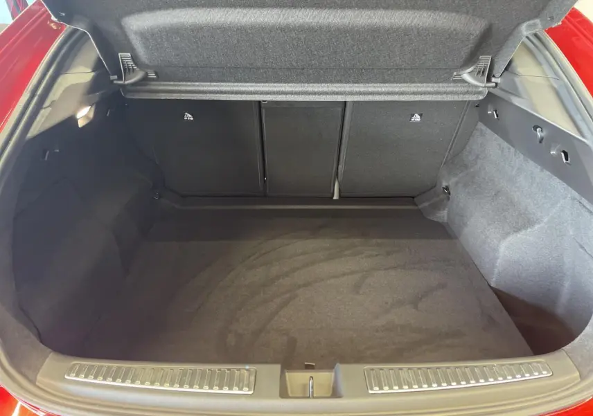 Coffre ouvert vu de l'arrière d'une Renault Rafale 2025 rouge avec intérieur de coffre noir et tapis plat.