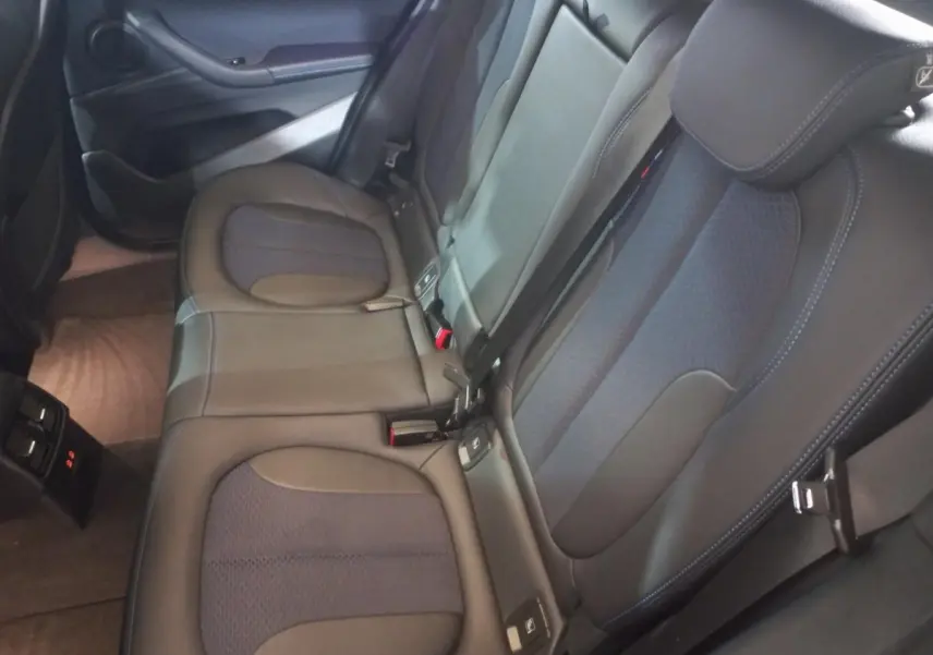 Vue intérieure des sièges arrière en cuir noir et tissu bleu foncé du BMW X1 xDrive20d M Sport 2022, côté droit.