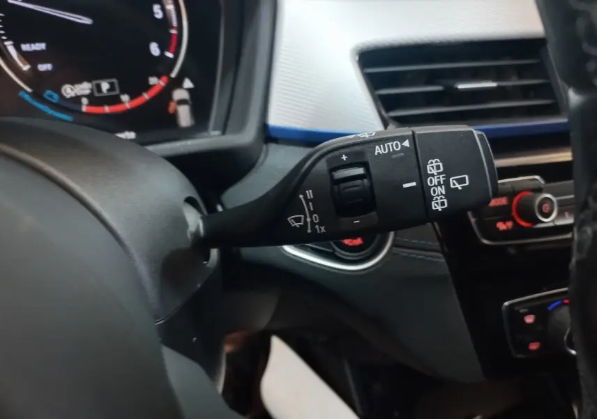 Gros plan sur la commande d’essuie-glace côté gauche du tableau de bord noir du BMW X1 xDrive20d 2022.