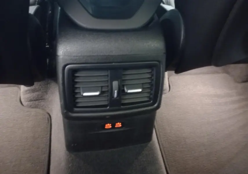 Vue rapprochée des aérateurs arrière noirs et prises USB orange du BMW X1 xDrive20d M Sport 2022.