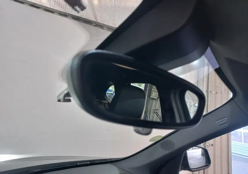 Rétroviseur intérieur d'un BMW X1 noir 2022, vue rapprochée sur l'intérieur et la vitre latérale droite.