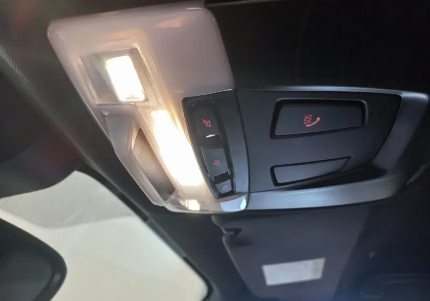 Vue intérieure en plongée du plafonnier noir et blanc avec boutons d’éclairage et alerte SOS du BMW X1 xDrive20d M Sport 2022.