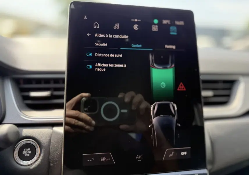 Écran tactile central du Renault Captur 2025 affichant les aides à la conduite, avec bouton start/stop visible à gauche.