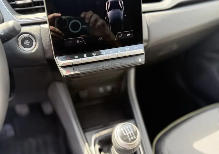 Gros plan sur la console centrale du Renault Captur 2025, montrant la boîte manuelle et l'écran tactile.
