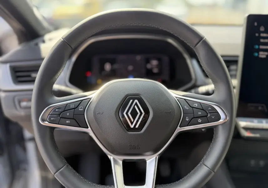 Volant cuir noir de Renault Captur 2025 vu de face, avec commandes intégrées et logo chromé central.