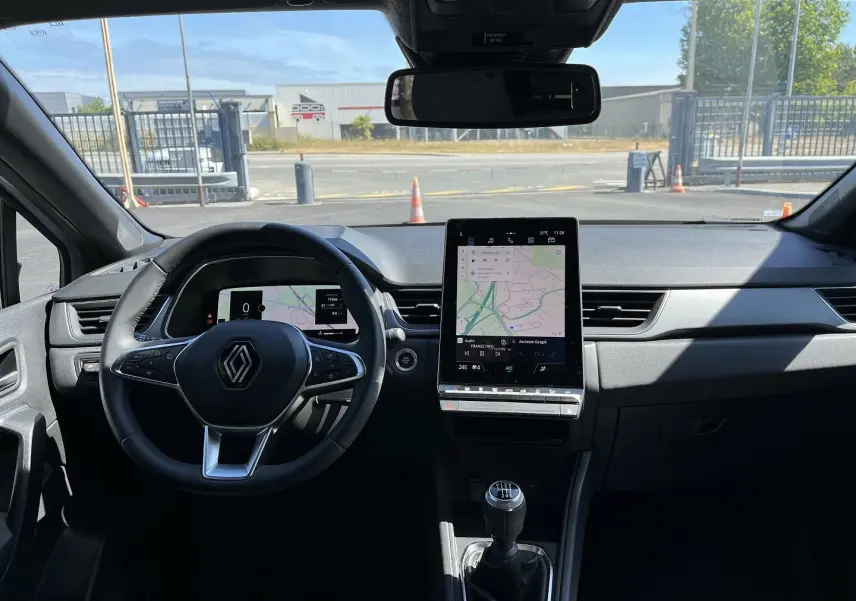Vue 3/4 arrière droite du Renault Captur 2025 gris Rafale avec toit noir et feux arrière LED distinctifs.