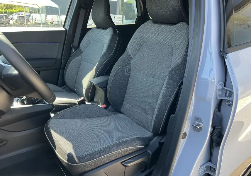 Gros plan sur la roue avant droite du Renault Captur gris Rafale avec jante noire et argentée au design étoilé.