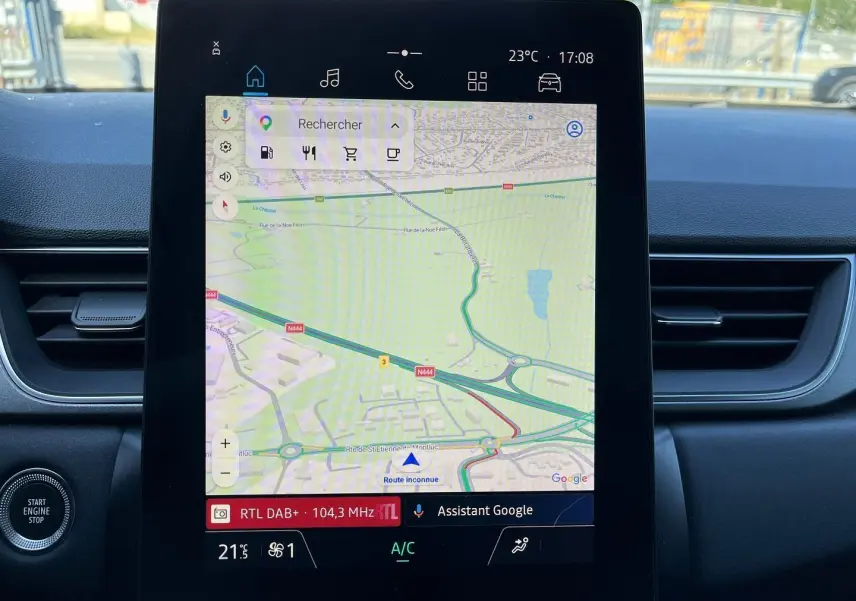 Vue intérieure du tableau de bord du Renault Captur 2025, écran tactile central affichant la navigation et commandes climatisation.