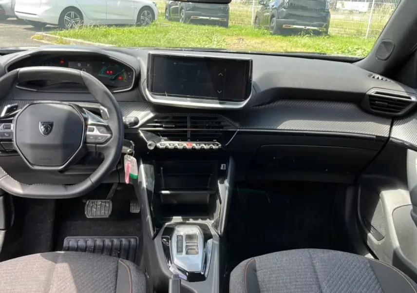 Vue intérieure frontale du tableau de bord et volant noir du Peugeot 2008 1.2 hybrid 145 style e-dcs6, avec écran tactile central.