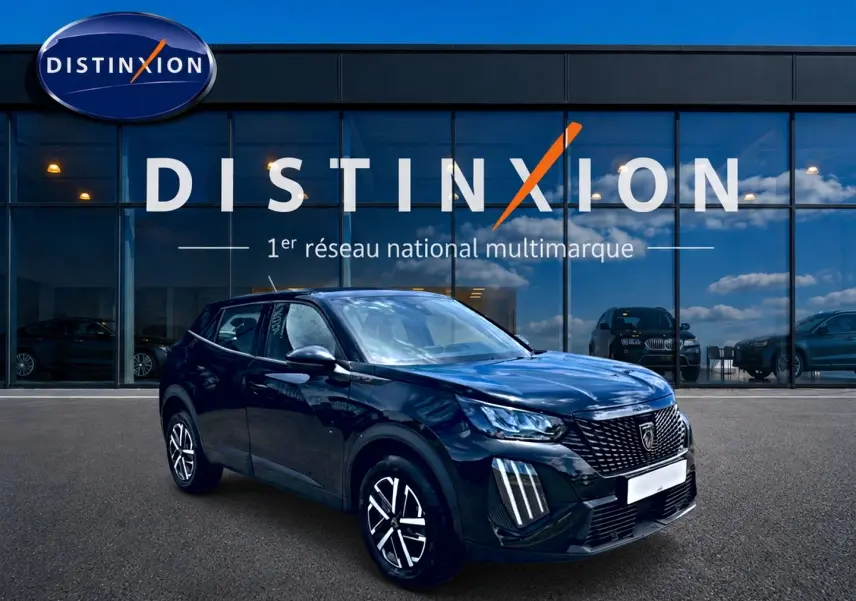Peugeot 2008 noir en 3/4 avant droit, avec calandre distinctive et feux LED verticaux, devant showroom Distinxion.