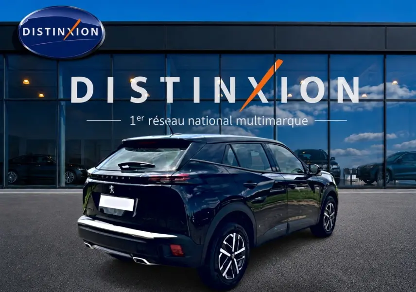 Vue 3/4 arrière droite d’un Peugeot 2008 noir brillant avec feux arrière LED et becquet, devant une vitrine Distinxion.