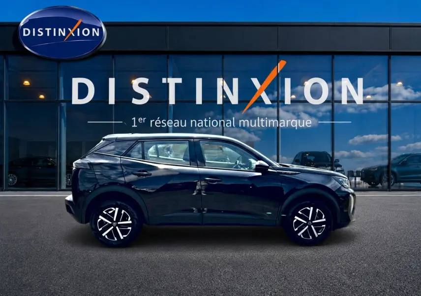 Profil côté gauche d'un Peugeot 2008 noir 2025, avec jantes distinctives, devant une vitrine Distinxion.