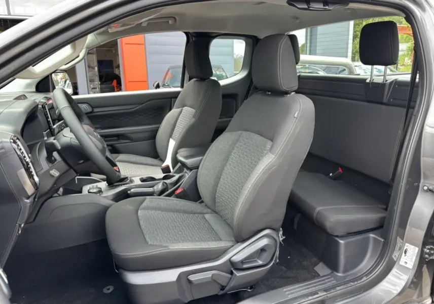 Intérieur du Ford Ranger 2025 gris carbone, vue côté gauche montrant les sièges avant et arrière Supercab avec sellerie tissu.