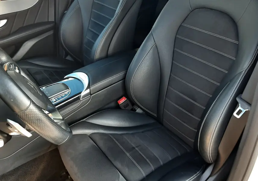 Vue rapprochée des sièges avant en cuir noir et alcantara du Mercedes GLC Coupé blanc, avec console centrale visible.