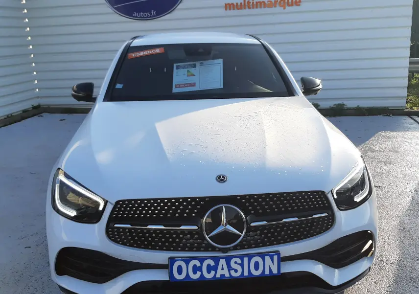 Vue de face d'une Mercedes GLC Coupé 300 4MATIC AMG Line blanche avec calandre AMG et plaque "OCCASION" visible.