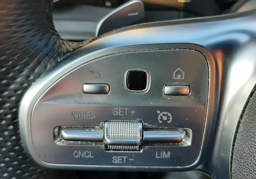 Gros plan sur les commandes de régulateur de vitesse au volant d'un Mercedes GLC Coupé blanc 2019.