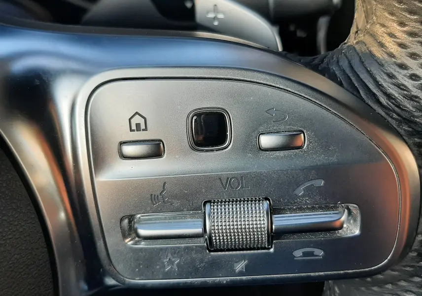 Gros plan sur les commandes de volume et téléphone au volant cuir noir d'une Mercedes GLC Coupé blanc 2019 AMG Line