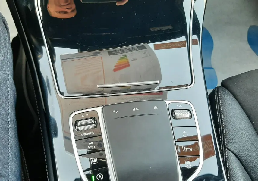 Gros plan sur la console centrale noire brillante du Mercedes GLC Coupé 300 AMG Line, avec commandes tactiles et molette de volume.