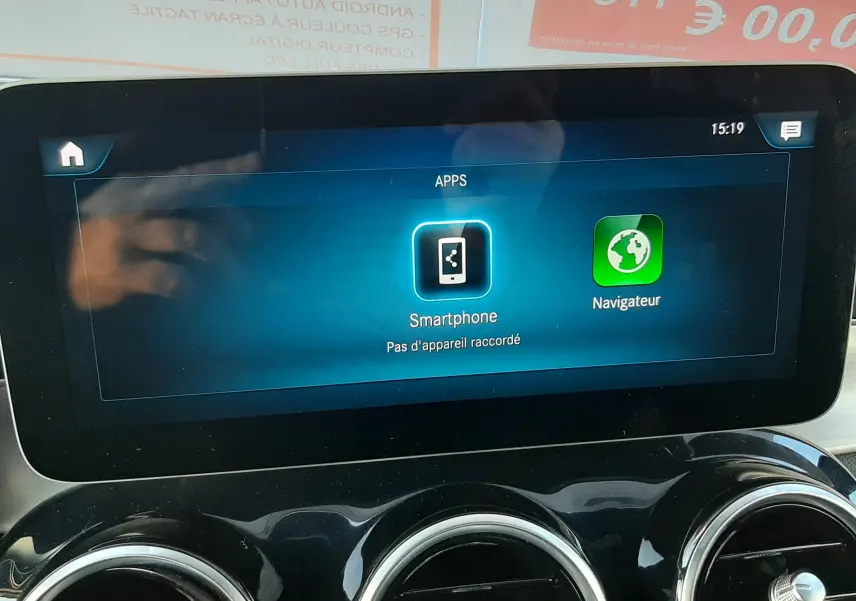 Écran tactile central affichant les applications smartphone et navigation, avec trois aérateurs ronds en dessous, intérieur Mercedes GLC.