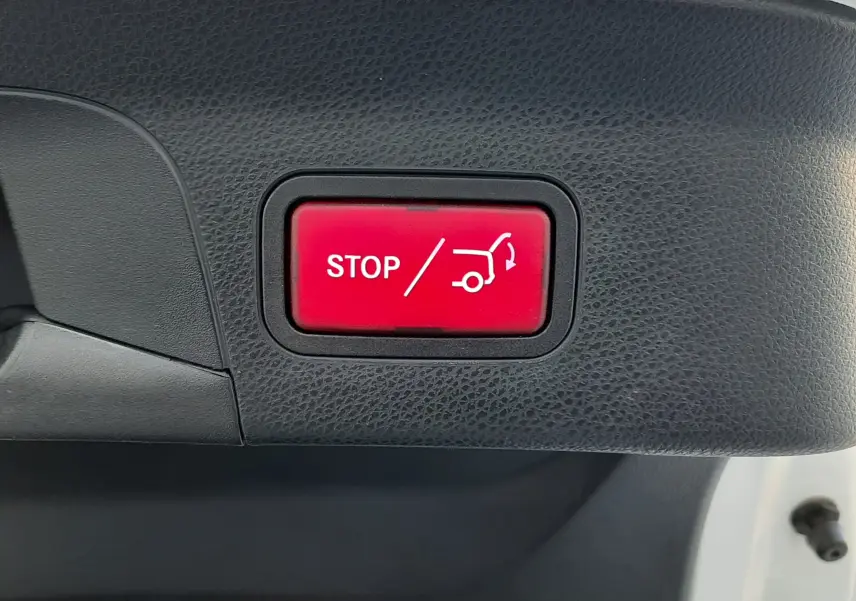 Bouton rouge "STOP" pour fermeture automatique du hayon, intérieur noir du coffre d'un Mercedes GLC Coupé blanc 2019.