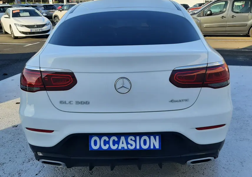 Vue arrière d'un Mercedes GLC 300 4MATIC Coupé blanc avec feux LED et double sortie d'échappement chromée.