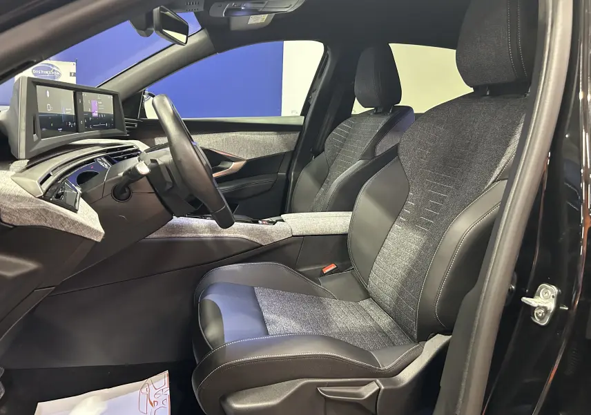 Intérieur du Peugeot 3008 III Hybrid 145 vue côté gauche, sièges bi-matière gris et noir avec tableau de bord numérique.