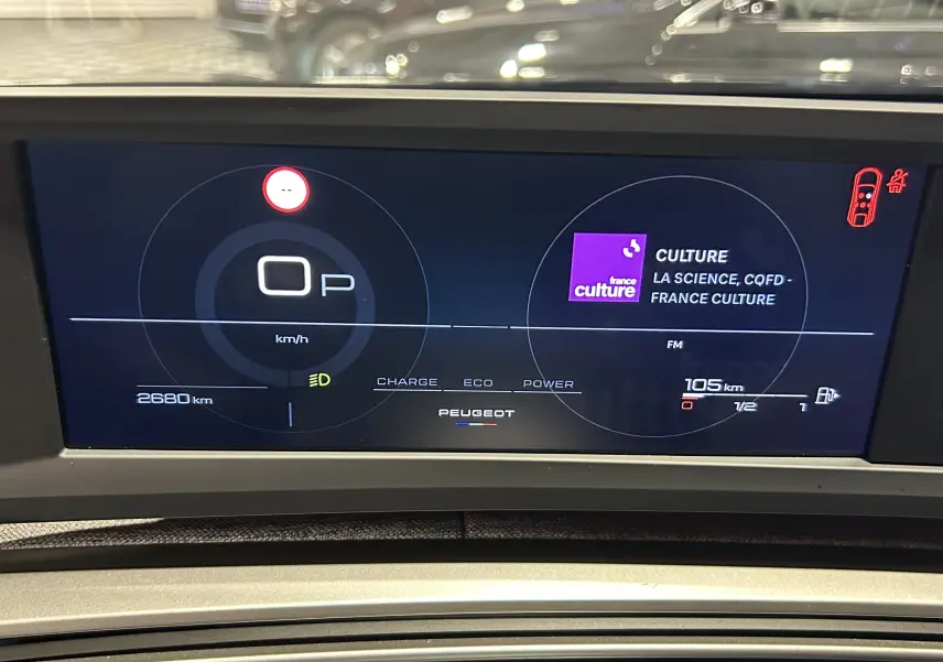 Affichage numérique du tableau de bord du Peugeot 3008 hybride, montrant la vitesse à 0 km/h et la radio France Culture.
