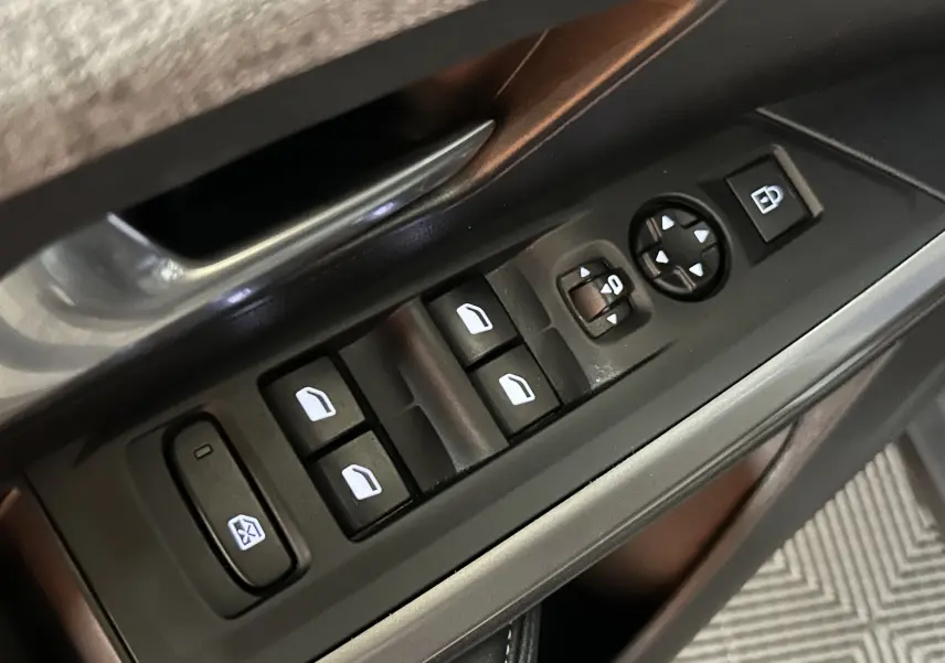 Gros plan sur les commandes de vitres électriques et rétroviseurs côté gauche d’un Peugeot 3008 noir, version 2025.