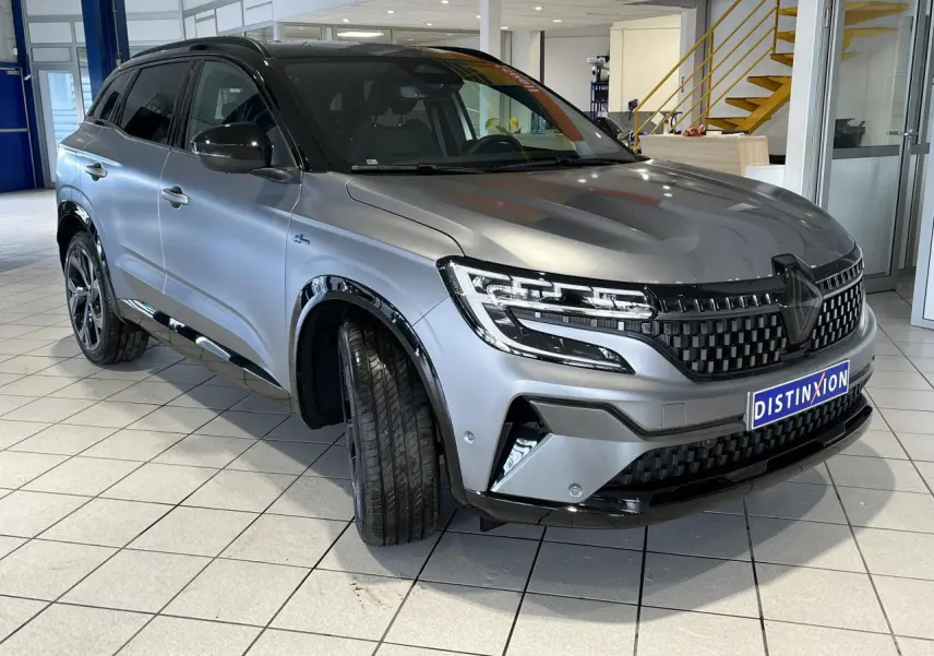 Vue 3/4 avant droit du Renault Austral gris avec calandre damier ice black et jantes alliage 20 pouces Daytona.