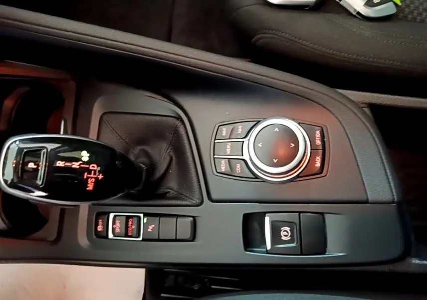 Vue rapprochée de la console centrale noire du BMW X1 2020 avec levier de vitesses automatique et molette de commande.