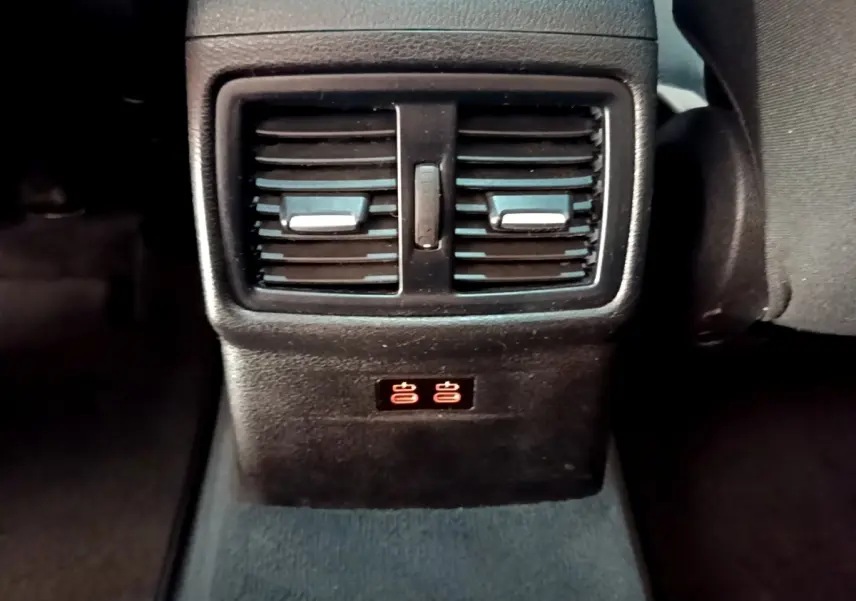 Détail des aérateurs arrière et ports USB illuminés dans l’habitacle noir du BMW X1 sDrive20i 2020.