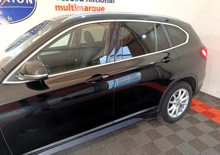 Vue latérale droite d'un BMW X1 noir 2020 avec jantes alliage et rétroviseurs électriques rabattables.