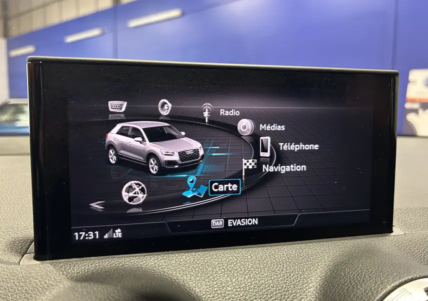 Écran du virtual cockpit montrant la navigation et un Audi Q2 gris en vue 3/4 avant dans l'interface multimédia.