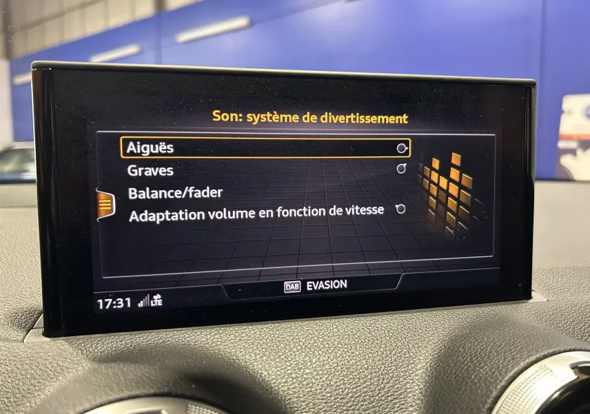 Écran central de l'Audi Q2 gris 2023 montrant le menu son du système de divertissement intérieur.