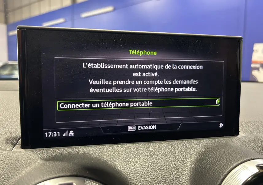 Écran central de l'Audi Q2 gris 2023 affichant la connexion Bluetooth pour téléphone portable, vue intérieure frontale.