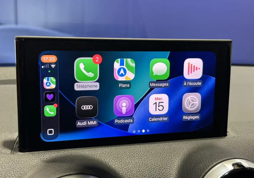 Écran tactile central de l'Audi Q2 TFSI 110 gris, affichant l'interface Apple CarPlay avec applications visibles.