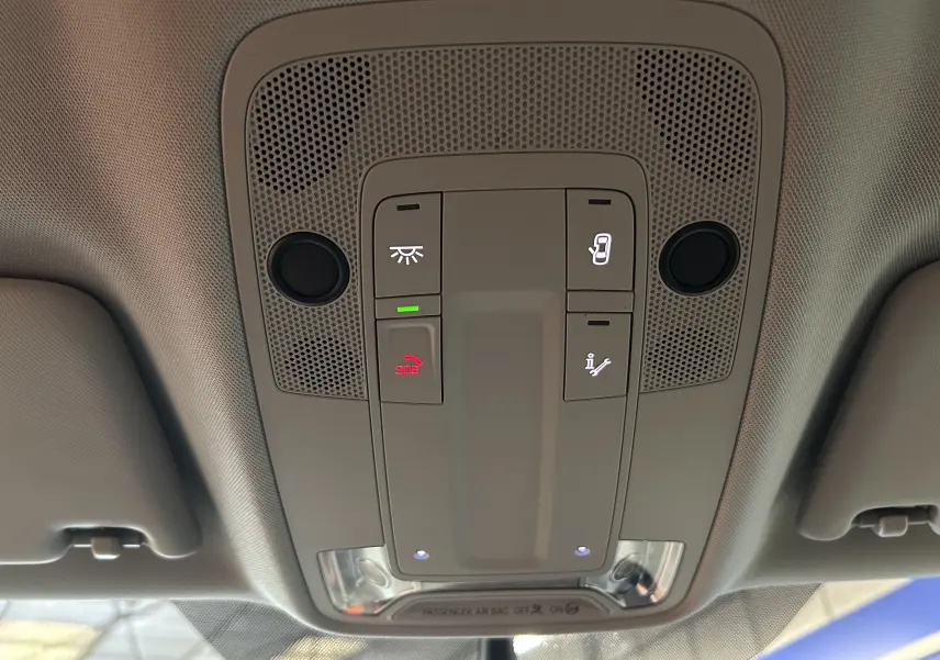 Vue en gros plan du plafonnier intérieur gris de l'Audi Q2 2023 avec commandes d'éclairage et bouton SOS allumé.