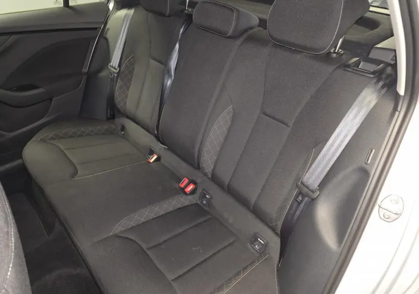 Vue intérieure de la banquette arrière noire du Skoda Kamiq 2023, avec ceintures de sécurité et appuie-têtes visibles.