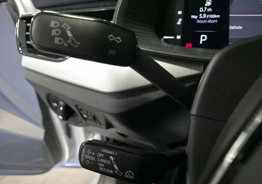 Gros plan sur les commandes au volant du Skoda Kamiq 2023, avec affichage digital et leviers multifonctions noirs.