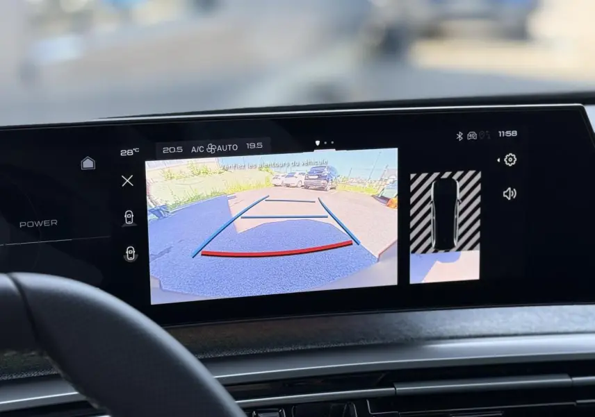 Vue intérieure sur l'écran tactile du Peugeot 5008 Hybrid noir Perla affichant la caméra de recul et l'aide au stationnement.
