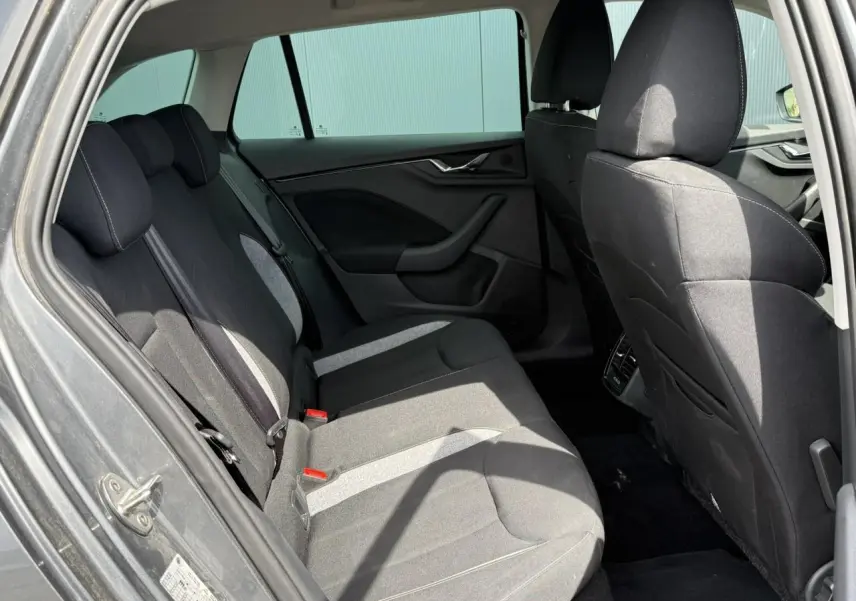 Vue intérieure côté gauche montrant la banquette arrière noire avec inserts gris d'une Skoda Scala Gris Graphite 2025.