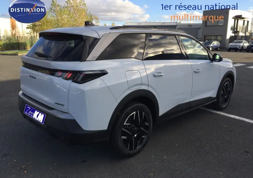 Peugeot 5008 Hybrid blanc Okenite métal vu en 3/4 arrière droit, avec jantes noires et vitres teintées.