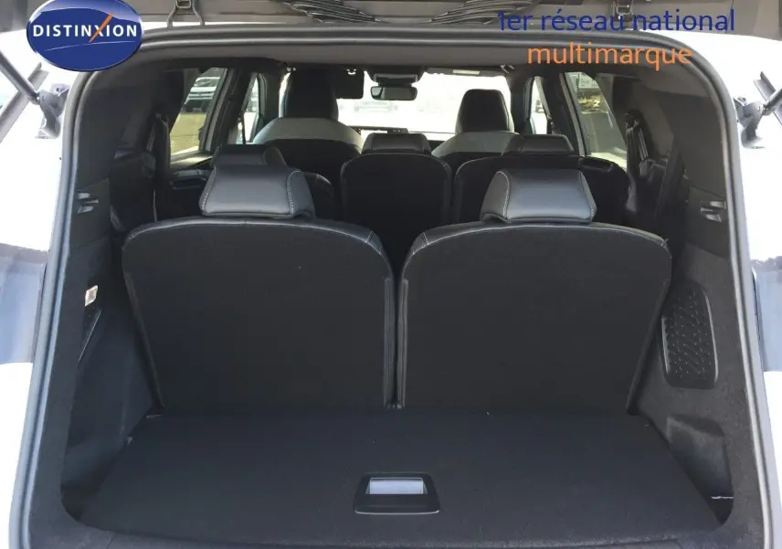 Vue arrière du coffre ouvert du Peugeot 5008 blanc Okenite Metal, montrant les sièges arrière en position verticale.