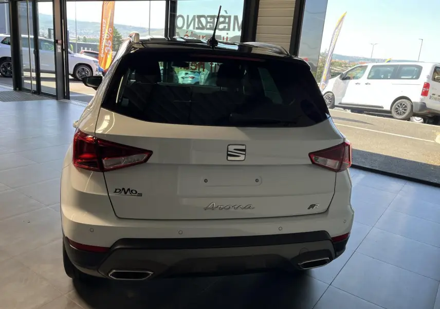 Vue arrière d'un SEAT Arona blanc Nevada 2024 avec logo FR et double sortie d'échappement en concession.