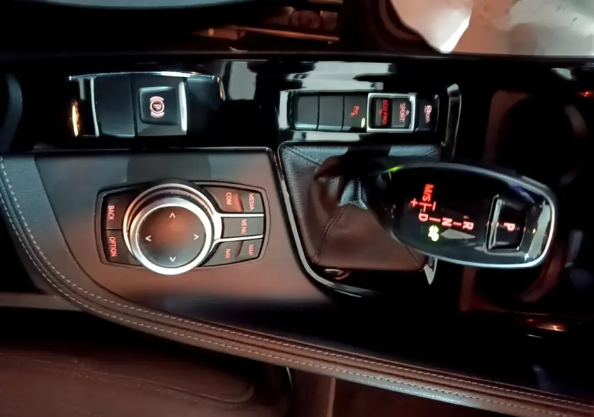 Vue rapprochée de la console centrale noire du BMW X2 2023 avec levier de vitesse automatique et molette de contrôle.