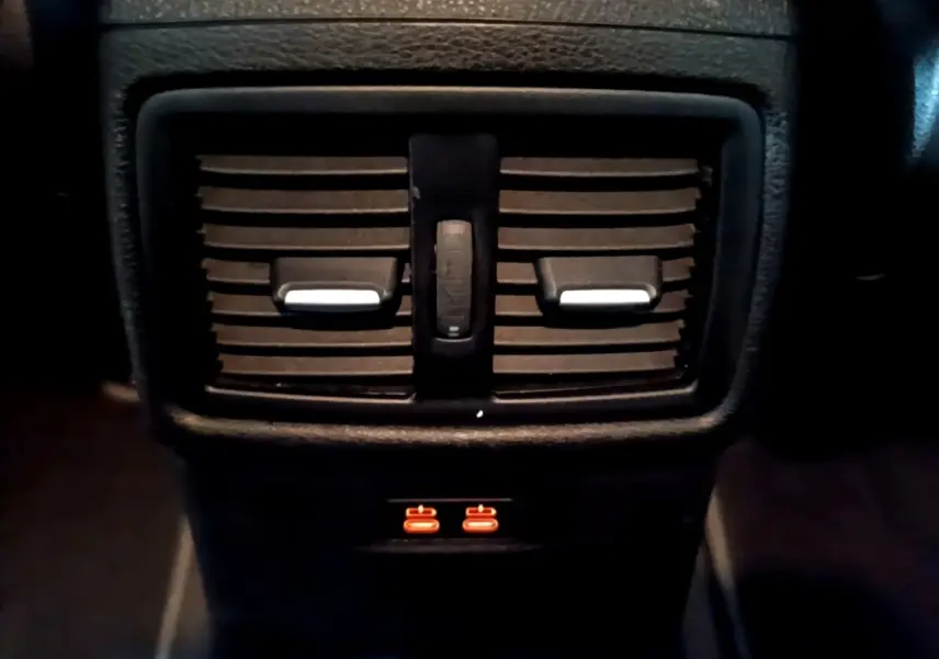 Gros plan sur les aérateurs arrière noirs et les ports USB illuminés du BMW X2 sDrive18i Lounge DKG7 2023.