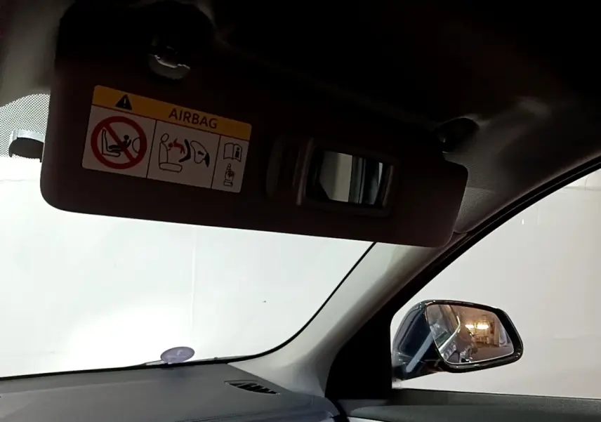 Vue intérieure côté conducteur du BMW X2 sDrive18i Lounge 2023, avec pare-soleil et rétroviseur noir visible.