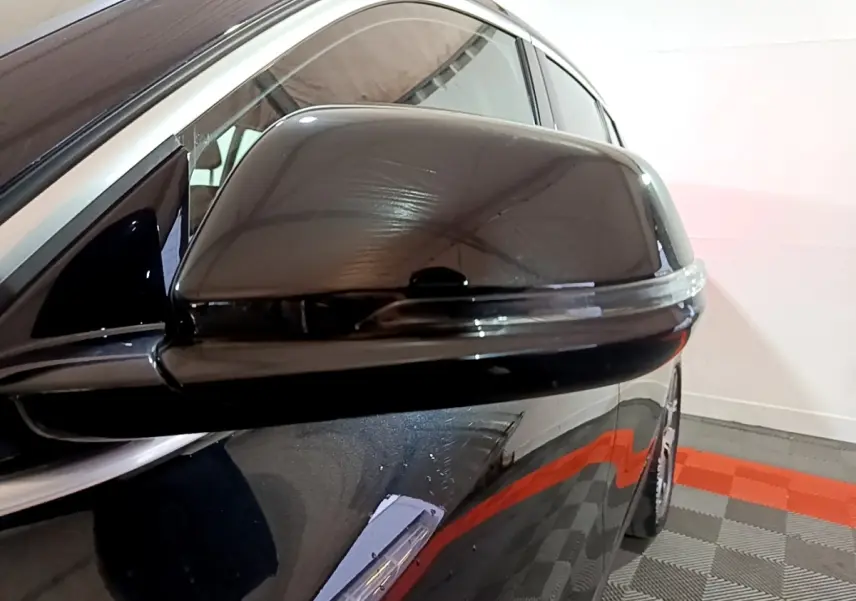 Gros plan sur le rétroviseur droit noir brillant du BMW X2 sDrive18i Lounge 2023 avec clignotant intégré.