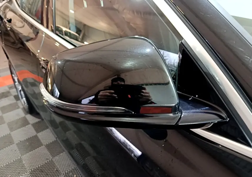 Gros plan sur le rétroviseur droit noir brillant du BMW X2 sDrive18i Lounge 2023 avec clignotant intégré.